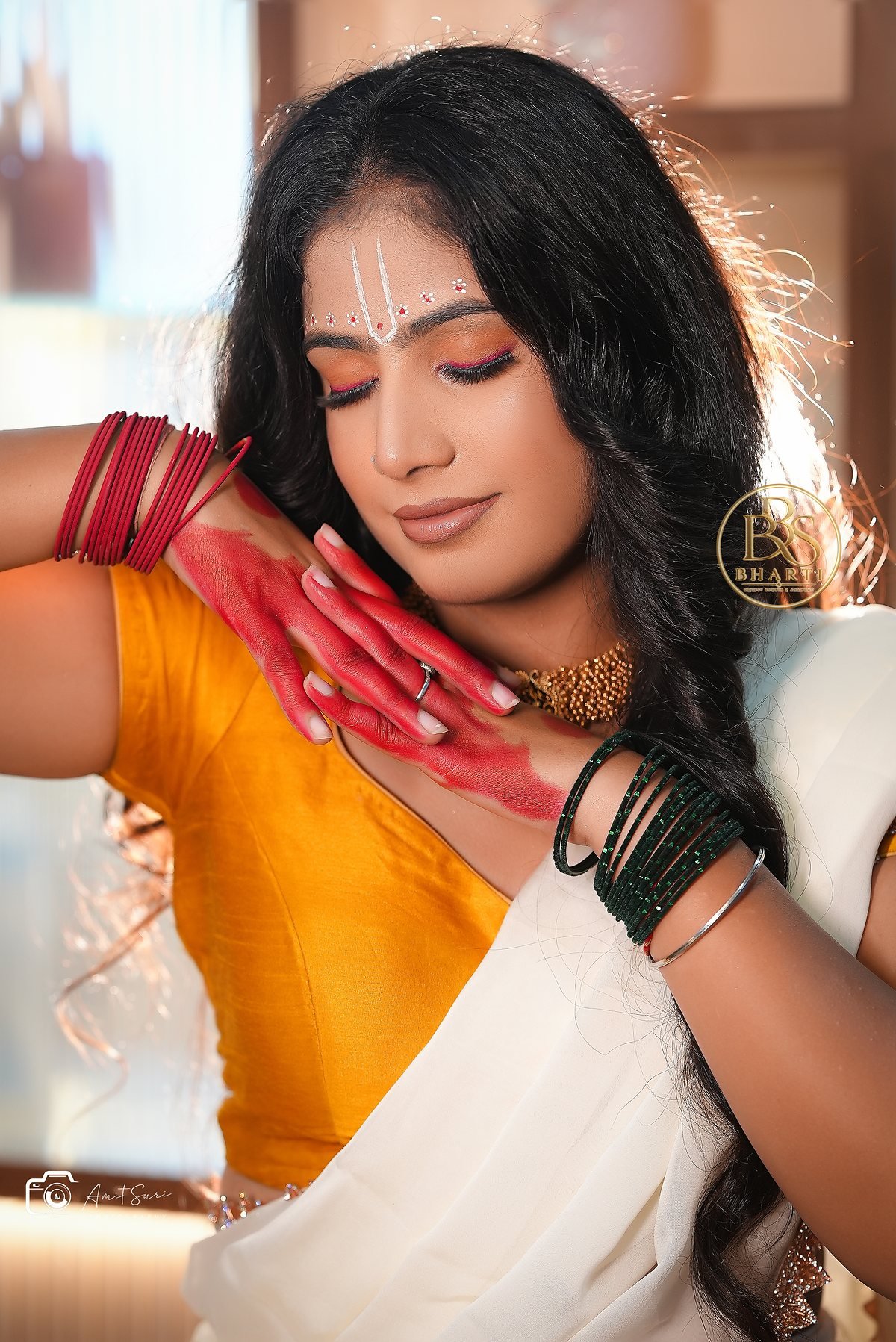 Radha-inspired model styling by Bharti: yellow blouse, ivory saree, devotional forehead detail and floral jewellery.